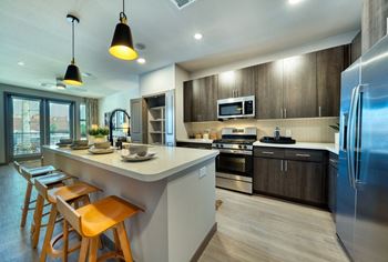 a kitchen with a large island and wooden stools